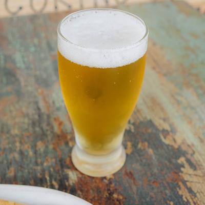 A glass of beer on a table.