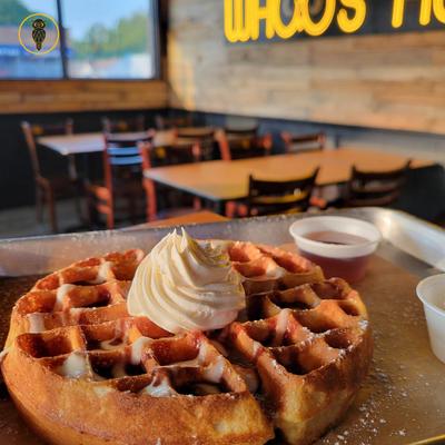 Sweet cream delight waffle with restaurant's interior in the background.