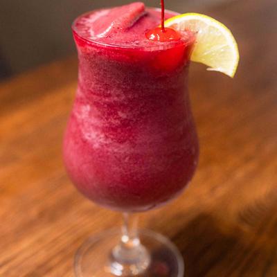 Blueberry Daiquiri garnished with cherry and lemon.