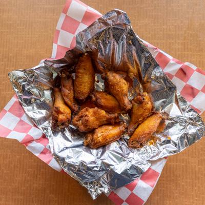 Chicken wings served in a foil-lined basket.
