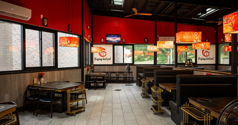 Modern and spacious interior dining area with tables equipped with built-in hot pot burners