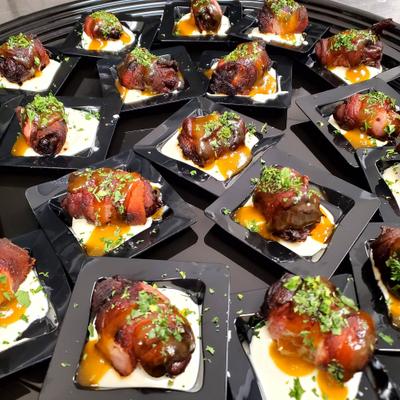 Glazed meat bites served on small square plates over a creamy, white base.