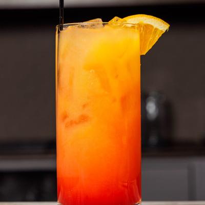 Tequila Sunrise cocktail garnished with a slice of orange.