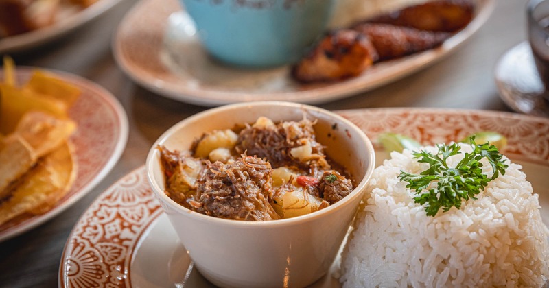 Beef with potatoes, served with rice, and plantains