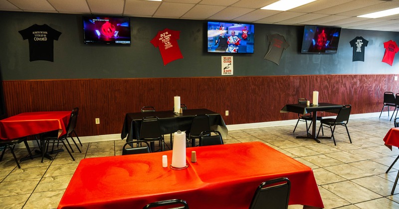 Interior, dining tables and seats, TVs and t-shirts on a wall