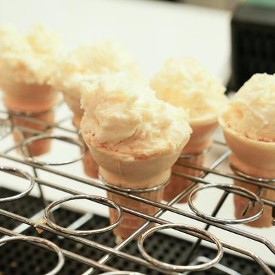 Several scoops of ice cream served in small wafer cones.