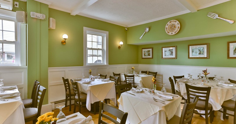 Tables and chairs in the corner of the room, framed pictures on the wall