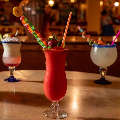 Three different cocktails with various garnishes served on a table.