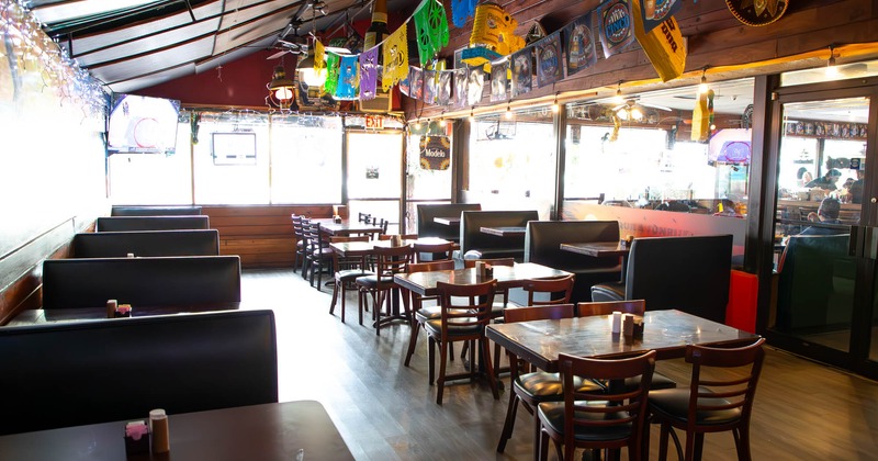 Interior, seating booths with tables, regular tables for four, entrance, TV in the corner