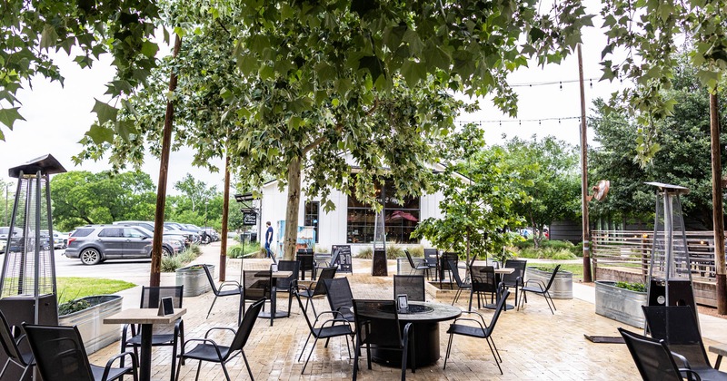 Exterior, seating area, regular tables and chairs, chairs around fire pit, yellow brick paving