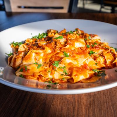 Plate of Pappardelle Bolognese served on a table.