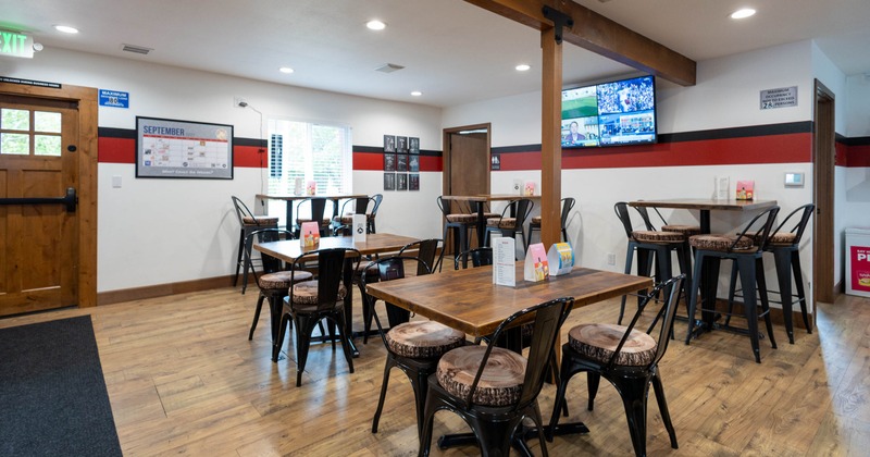 Interior seating area with wooden tables, metal chairs and a ceiling beam