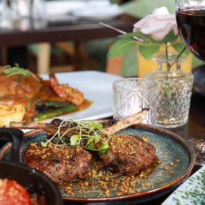 Multiple food plates and drinks on a table.