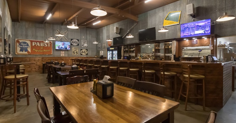 Diner area, table in front the bar and food counter, bar stools