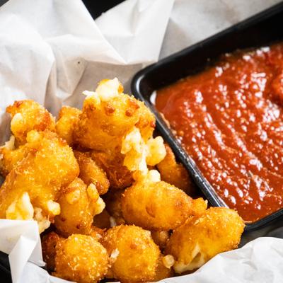 Garlic cheese curds served with a dipping sauce.