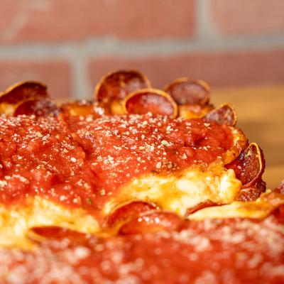 Close-up of a pepperoni pizza with tomato sauce and melted cheese.