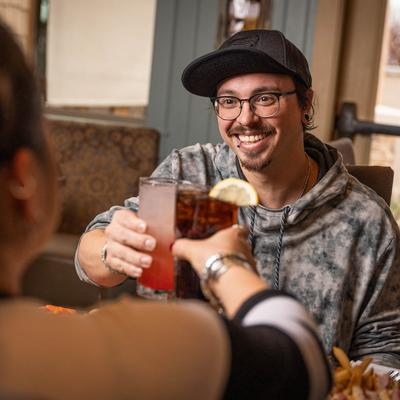 People toasting drinks with cocktails at the table.