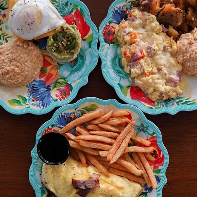 Colorful plates of breakfast dishes on a table.