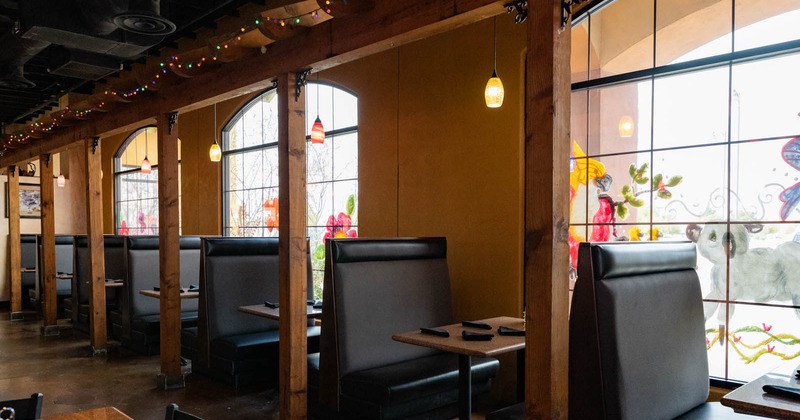 Interior, brown leather seating booths by the windows, tables, wooden posts