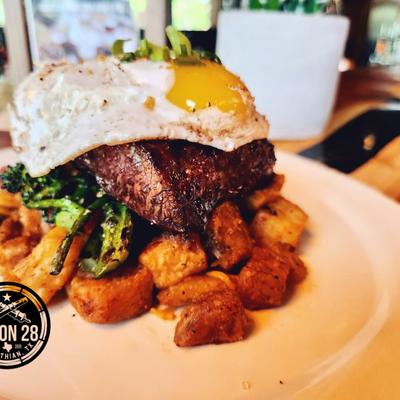 Platea of steak and eggs with home fries and broccolini