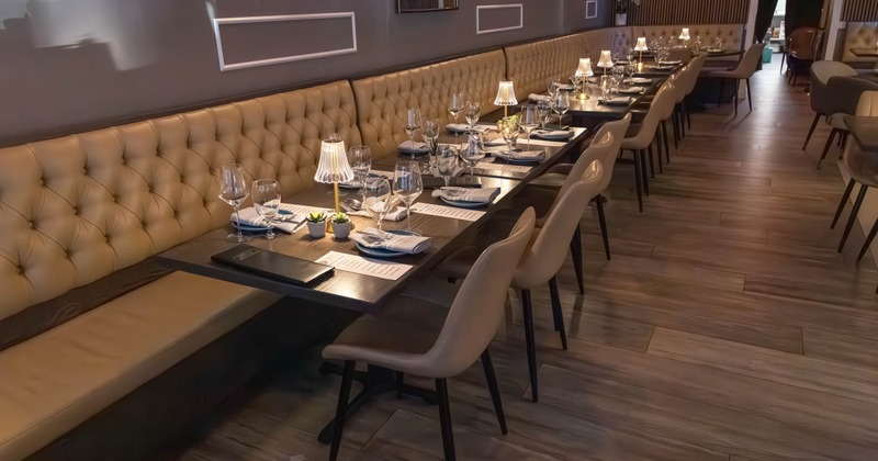 Interior, dining area, long banquette bench with tables and chairs, ready for guests
