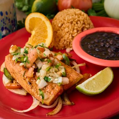 Grilled salmon served over fajita vegetables with rice, black beans, and pico de gallo.