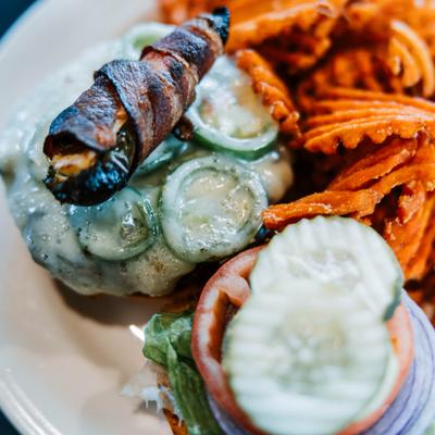 Cheeseburger topped with a bacon-wrapped jalapeno popper, served with sweet potato waffle fries.