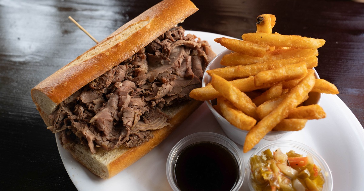 Italian beef sandwich served with sides of fries , au jus and giardiniera