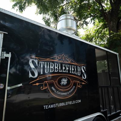 Black Stubblefield’s BBQ food truck parked under a tree.