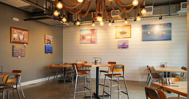 Interior, empty tables and seats, walls decorated with paintings of sea scenes