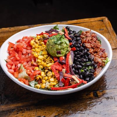 Burrito Bowl with guacamole, corn, black beans, tomatoes, peppers and bacon bits.