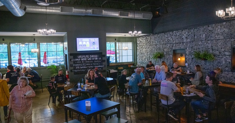 Interior space, seating area full of guests chatting and enjoying their food and drinks