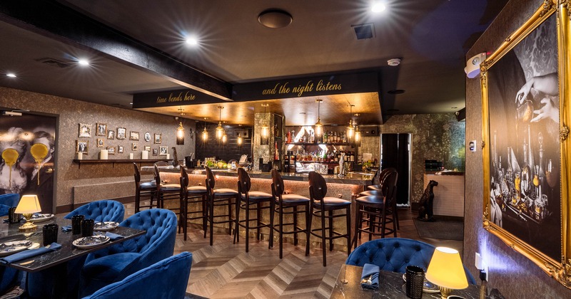 Interior of a modern bar featuring plush blue seating
