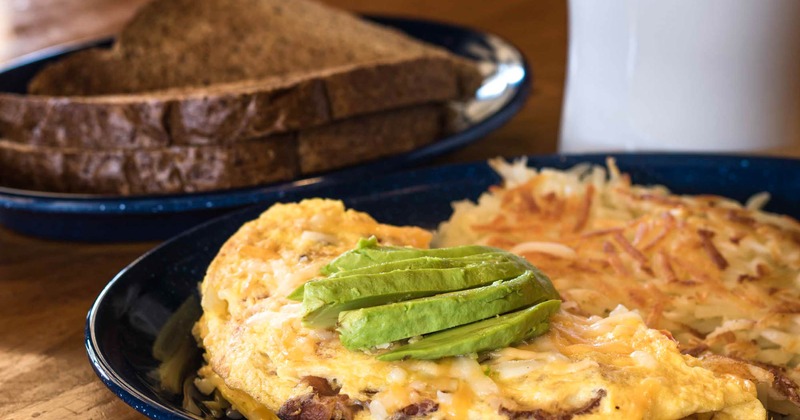Steak omelette, with avocado on top, and a side of hash browns