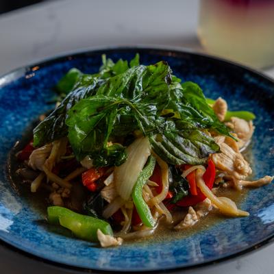 Stir Fry Chicken topped with Basil, served on a blue plate.