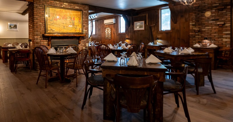 Interior, dining area, wooden tables and chairs, ready for guests, wood and brick walls