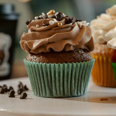 Chocolate cupcake topped with chocolate chips and pearl sprinkles.