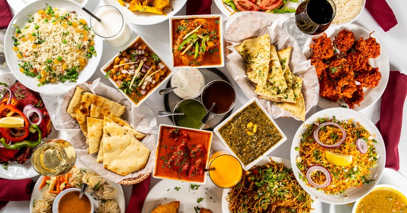 Variety of dishes and drinks spread on a table, overhead view