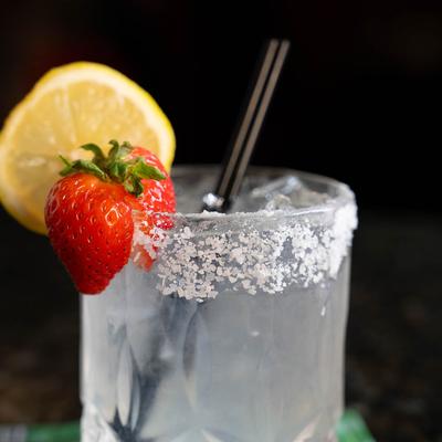 Close up of Rancher Water drink with sugar rim, lemon wheel, and a strawberry.