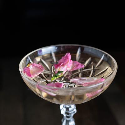Cocktail drink garnished with flower petals in the glass