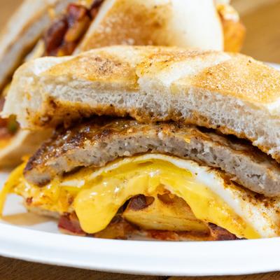 Breakfast sausage sandwich with egg and cheese, close-up.