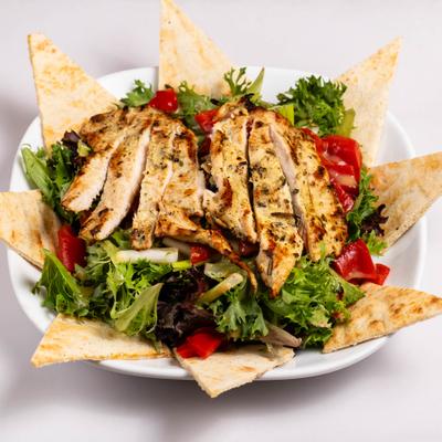 Grilled chicken salad, with lettuce, scallions, red peppers, and pita chips.