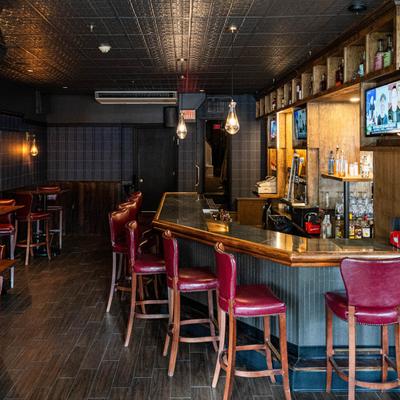 Bar interior with wooden accents and red leather stools