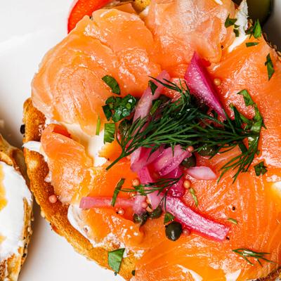 Bagels with lox, cream cheese, and pickled onions.