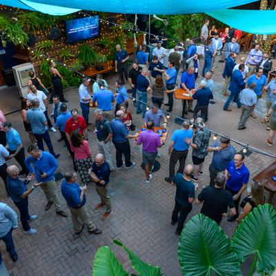 Gathering of people in casual attire socializing at an outdoor event.