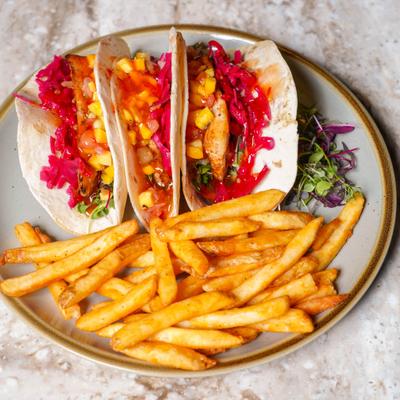 Mahi Mahi tacos served with fries.