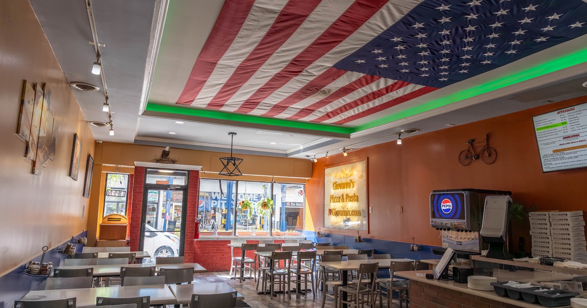 Interior - an American flag on the ceiling, tables and chairs and a counter with a Pepsi dispenser