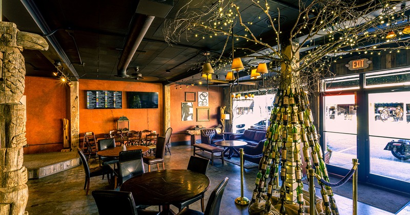 Interior, dining tables , lounge seating area, bottle tree decoration near the exit