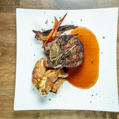 Bone in Filet Mignon served alongside roasted carrots and potatoes.