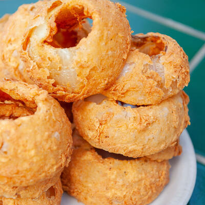 Onion rings stacked on a small round plate.